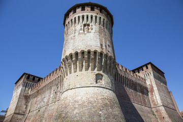 Fototapeta na wymiar Tower of medieval italian castle on blue sky