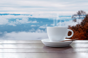 Morning coffee cup on beautiful landscape of mist and mountain