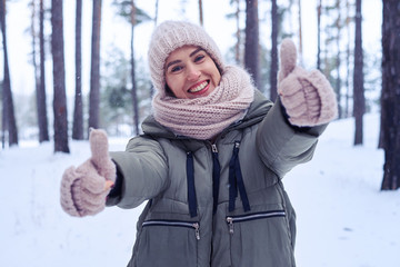 A woman giving a thumbs up sign of approval while standing in th