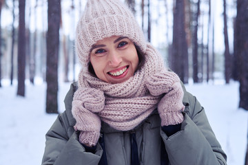 Exquisite smile of woman during the wintry walk in the forest