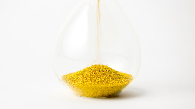 hourglass with gold beads on white background