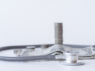Stethoscope and money coin stack on white background. money for health care, Financial Aid, concept.