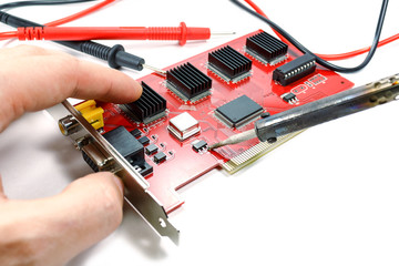 Replacement of electronic component on the DVR motherboard with a soldering iron on a white background