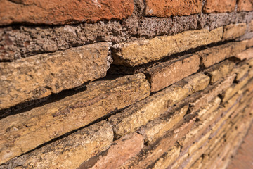 Ancient wall and sunlight. Cement and thin bricks. Touch the past.