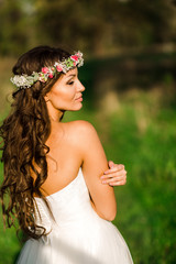 Beautiful bride in wedding dress and with a lovely mood in nature
