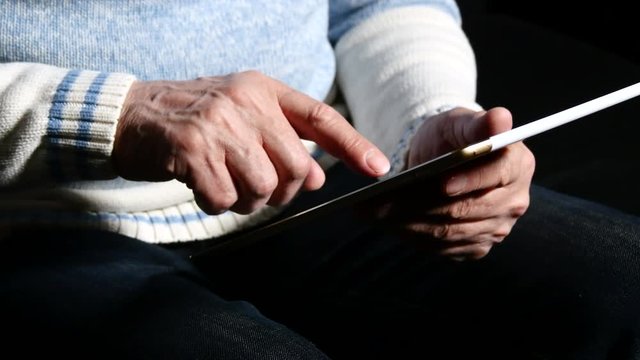 Man Using Tablet Sitting On Sofa, Close Up