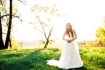 Beautiful bride in wedding dress and with a lovely mood in nature