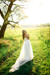 Beautiful bride in wedding dress and with a lovely mood in nature