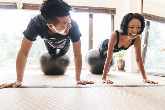 Man and woman exercising on fitness ball