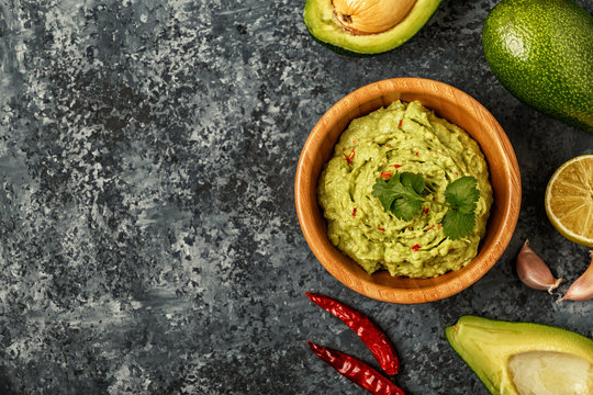 Homemade guacamole with ingredients.