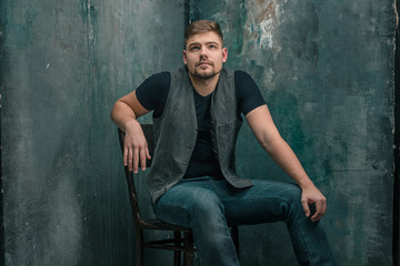 Portrait of serious man sitting on the chair in studio