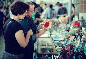 Ordinary tourists study the range of flea market