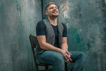 Portrait of smiling happy man sitting on the chair in studio