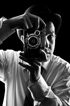 Young and attractive photographer in vintage suit and with retro