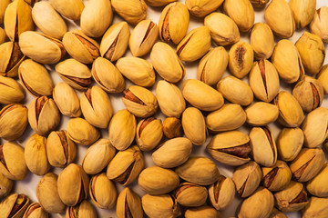 A lot of pistachios scattered everywhere creating a beautiful nuts food background.