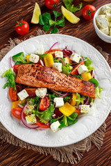Fried Salmon steak with fresh vegetables salad, feta cheese. concept healthy food.