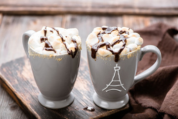 S'mores drink. Two mugs of hot chocolate with marshmallows on a wooden table. Cocoa.