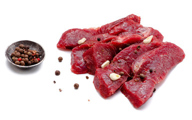 Pieces of meat with garlic isolated on white background. Raw beef. Top view.