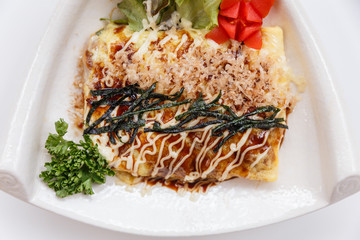 Japanese Omelette with Okonomiyaki Sauce Topping with Katsuobushi (dried, fermented, and smoked skipjack tuna), Seaweed and Mayonaise.