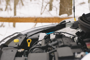 Car engine closeup with copy space. Outdoor photo showing concept winter car problems with ignition.