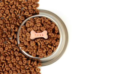 Dog bowl with pet feed, pink bone on half white background scattered dry food