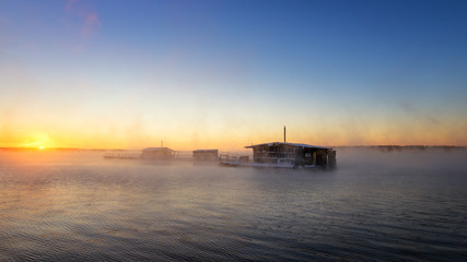 утренний пейзаж на озере с рыбацкими домиками в тумане, Россия, Урал
