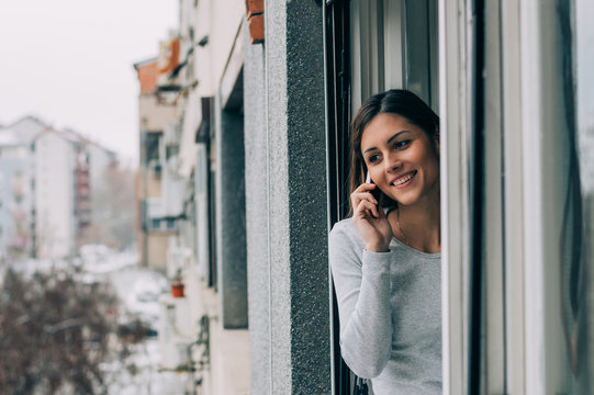 Beautiful smiling girl takling on the phone and looking throught
