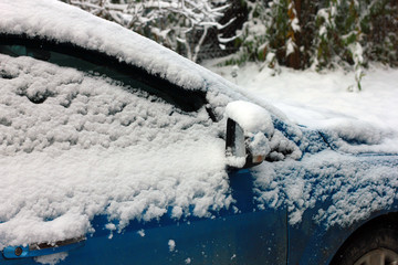 rear view mirror and side of car covered in snow