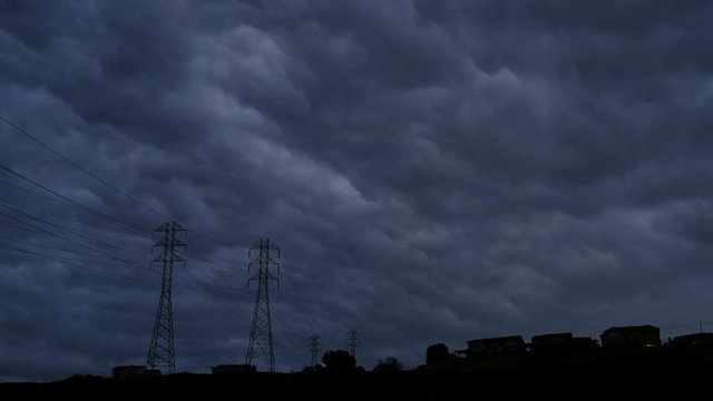 Dark storm clouds rolling in over power lines in California