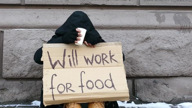 

4K. Homeless  despair man  in  city street with paper glass. Close up Unemployment symbol
