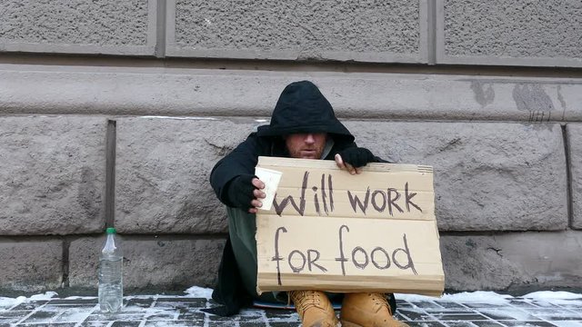 
4K.Some money for Homeless  despair man  in  city street . Unemployment symbol
