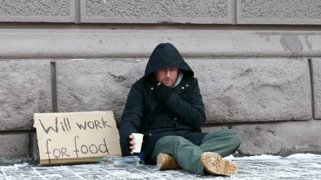 
4K.  Few money for Homeless  despair man  in  city street . Unemployment  beggar symbol
