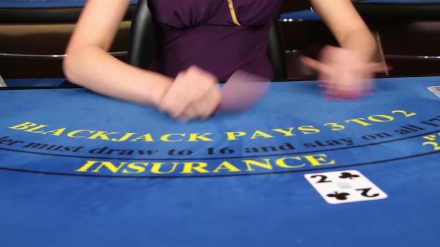 Croupier placing black jack and poker cards on the casino table, zoom shot of hands