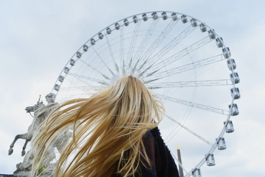 Grande Roue de Paris 19 May Paris, France. Girl with blond hair in front of Grande Roue. - Powered by Adobe