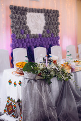Beautiful unusual wedding decor. Rustic Style. Bench, wall of flowers, lanterns at the photo zone.
