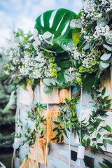 Beautiful unusual wedding decor. Rustic Style. Bench, wall of flowers, lanterns at the photo zone.