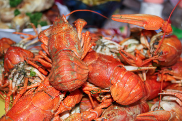 Red boiled crayfish on plate,  background with food