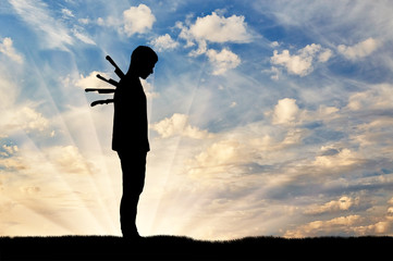Silhouette of a sad man with a knives in his back