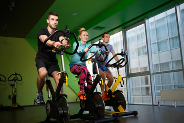 Young sportsmens on exercise bikes