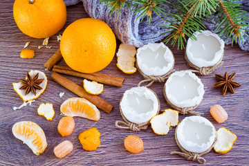 Чайные свечи, мандарины, пряности, конфеты, шарф и еловые ветки на деревянном столе