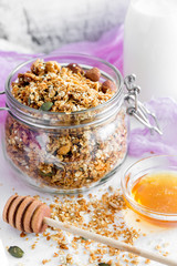 Food background of homemade granola with yogurt and honey on white table for healthy breakfast
