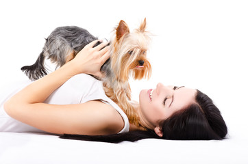 Beautiful young woman, lying with a cute dog breed Yorkshire Terrier