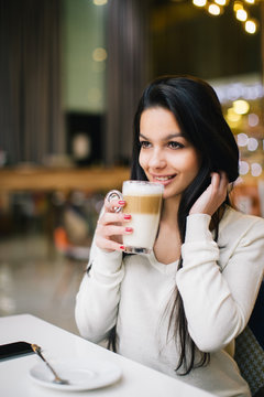 Young woman at cafe drinking coffee 