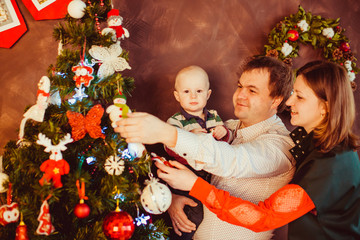 The father,mother and son decorating a Christmas Tree