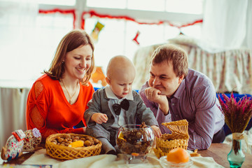 The mother,father and son sitting near table with nuts