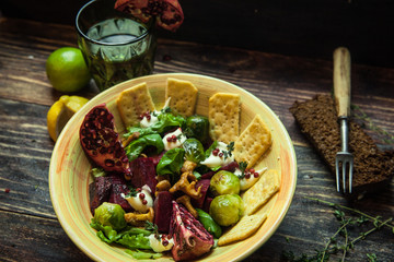 Fresh salad with chicken, tomatoes, crisps, mushrooms, cheese, fruits (arugula, mesclun, mache) on wooden background close up. Healthy food.