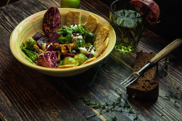 Fresh salad with chicken, tomatoes, crisps, mushrooms, cheese, fruits (arugula, mesclun, mache) on wooden background close up. Healthy food.