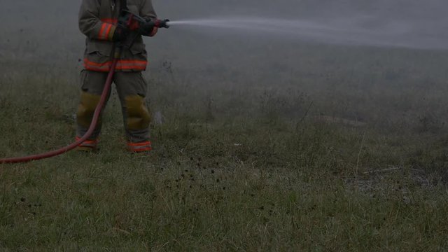 Firefighter putting out fire in farmers field