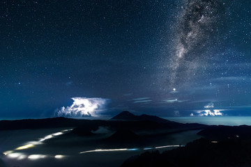 Vertical Milky way galaxy and thunder storms over Mount. Bromo a