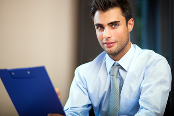 Portrait of a smiling young businessman sitting in his office